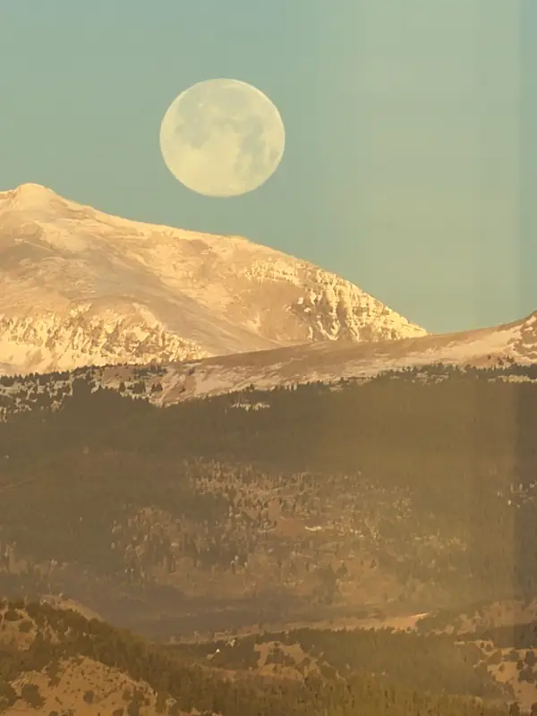 Full moon setting behind the high country